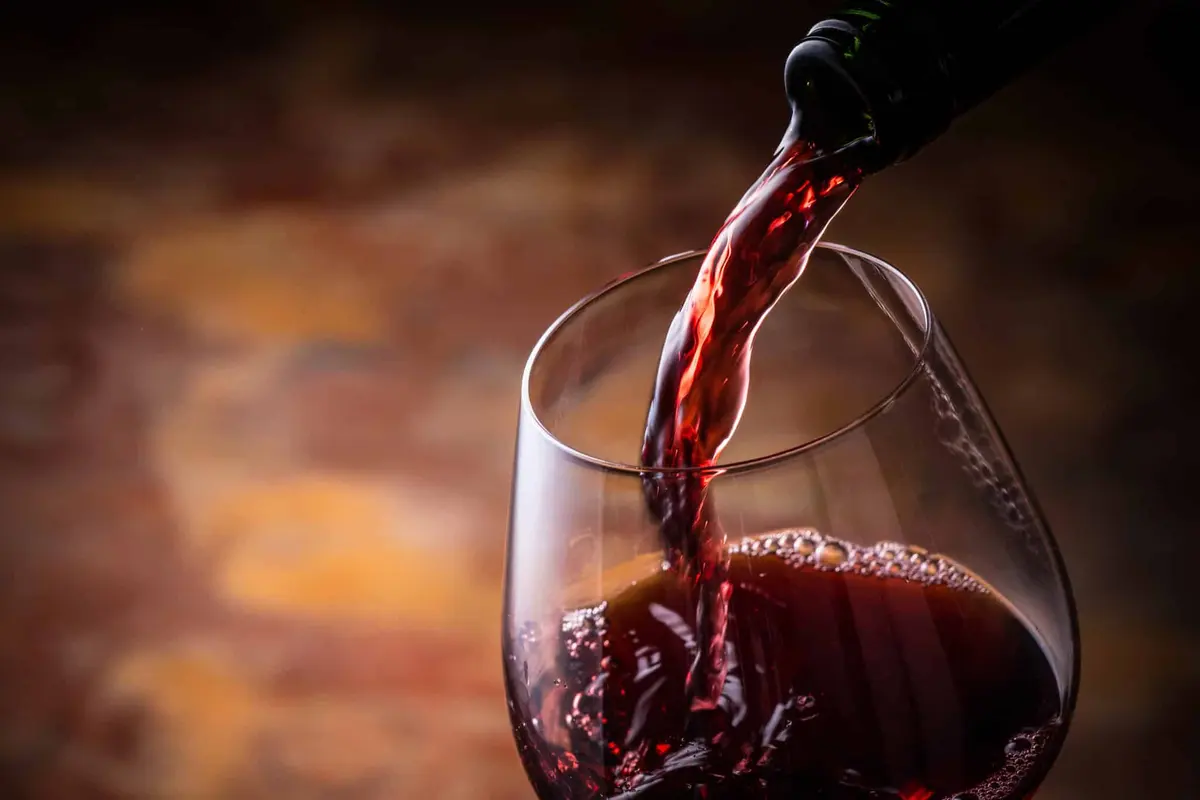 vinho tinto sendo servido na taça