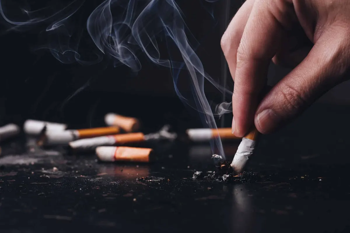 Close up hand held a cigarette to crush smoke of a burning, Stop smoking concept.World No Tobacco Day