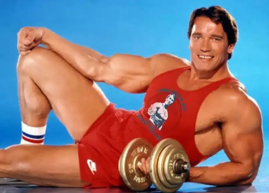 Arnold Schwarzenegger posando com halter