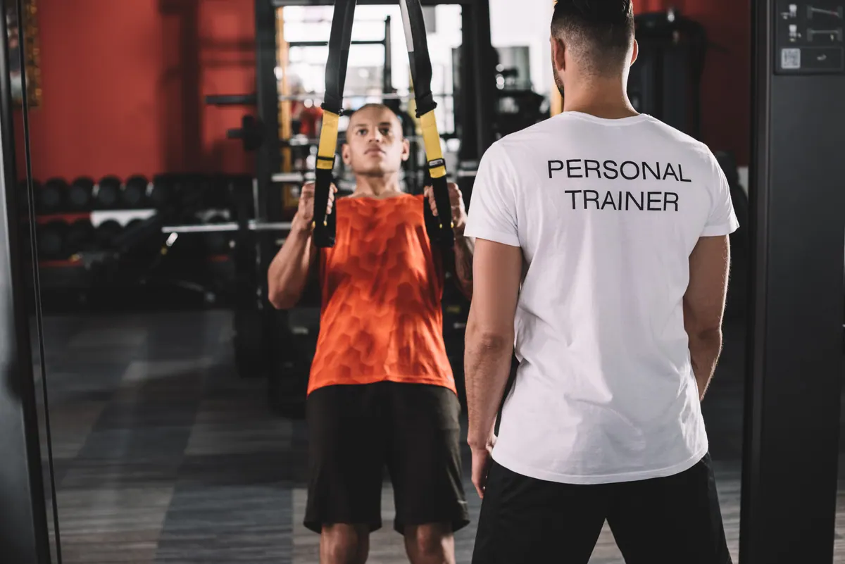Personal trainer orientando um aluno na academia