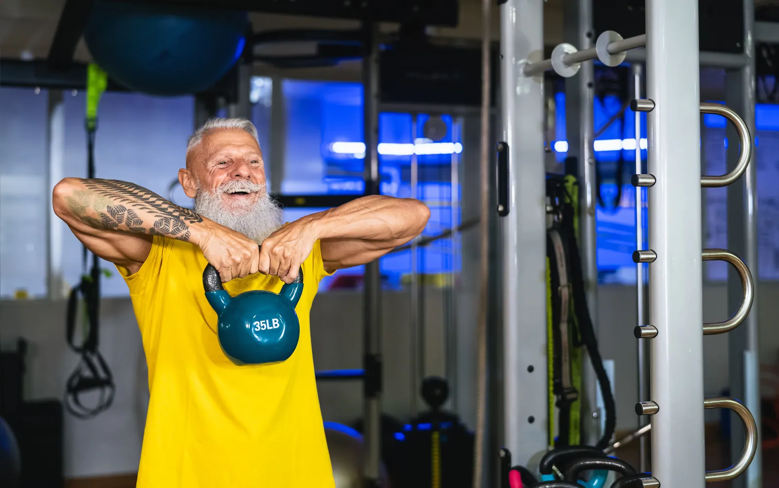 Homem mais velho treinando com kettlebell na academia