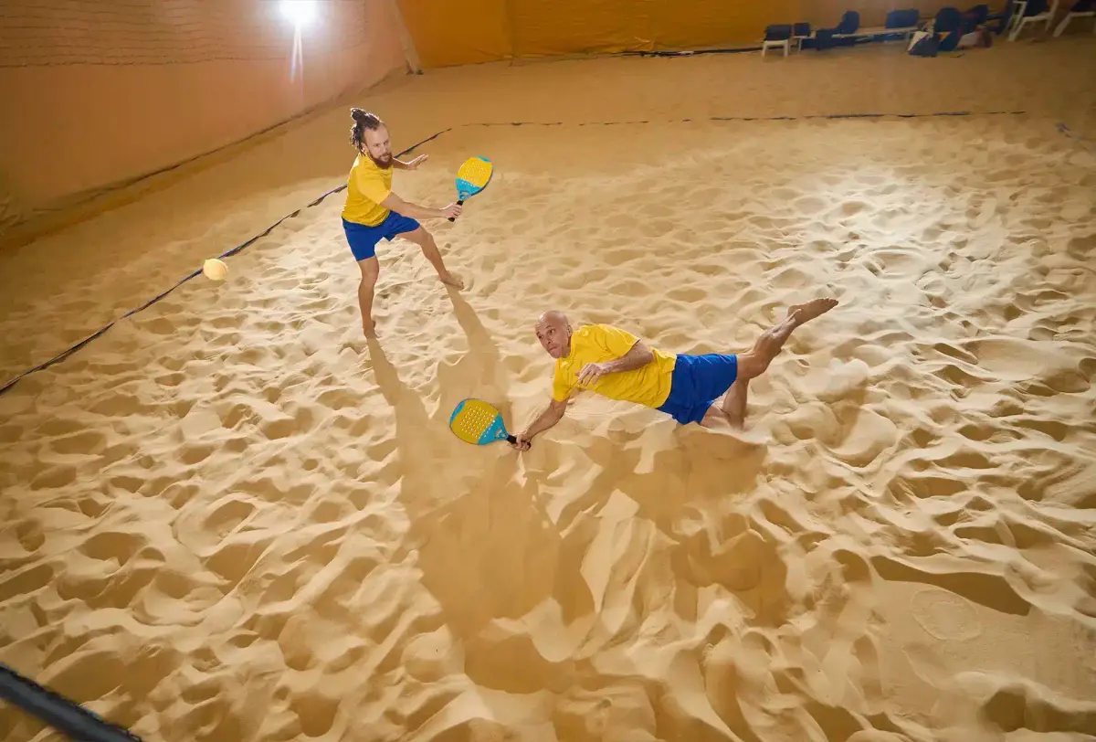 pessoas jogando beach tennis na areia
