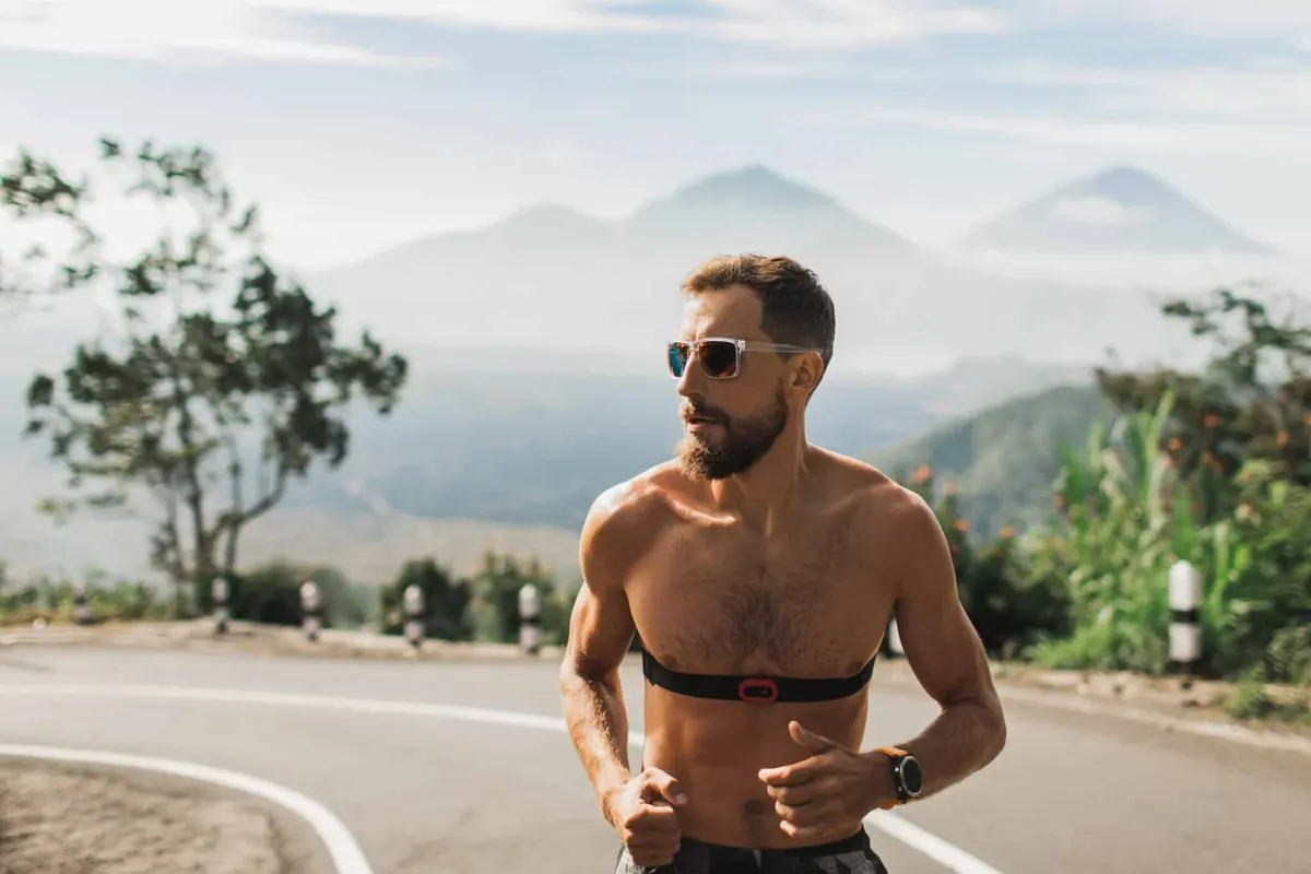 O Poder do Exercício na Prevenção de Doenças Cardíacas homem com frequecimentro correndo corrida de rua coração