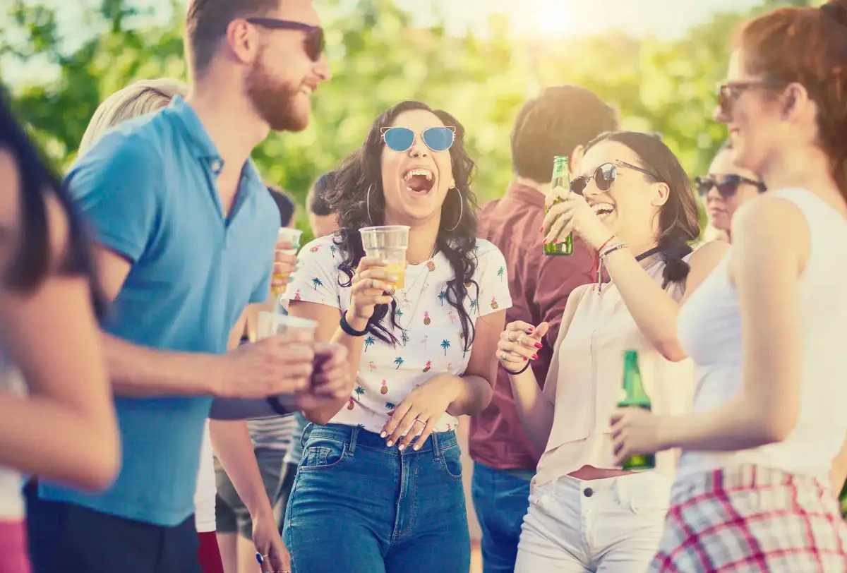 amigos rindo e bebendo em festa ao ar livre
