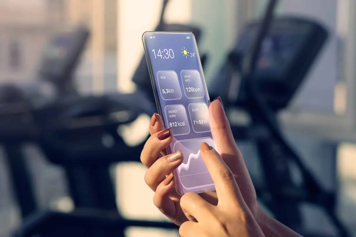 mão segurando celular com aplicativo na academia