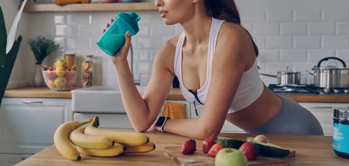 Mulher na cozinha com bananas e frutas