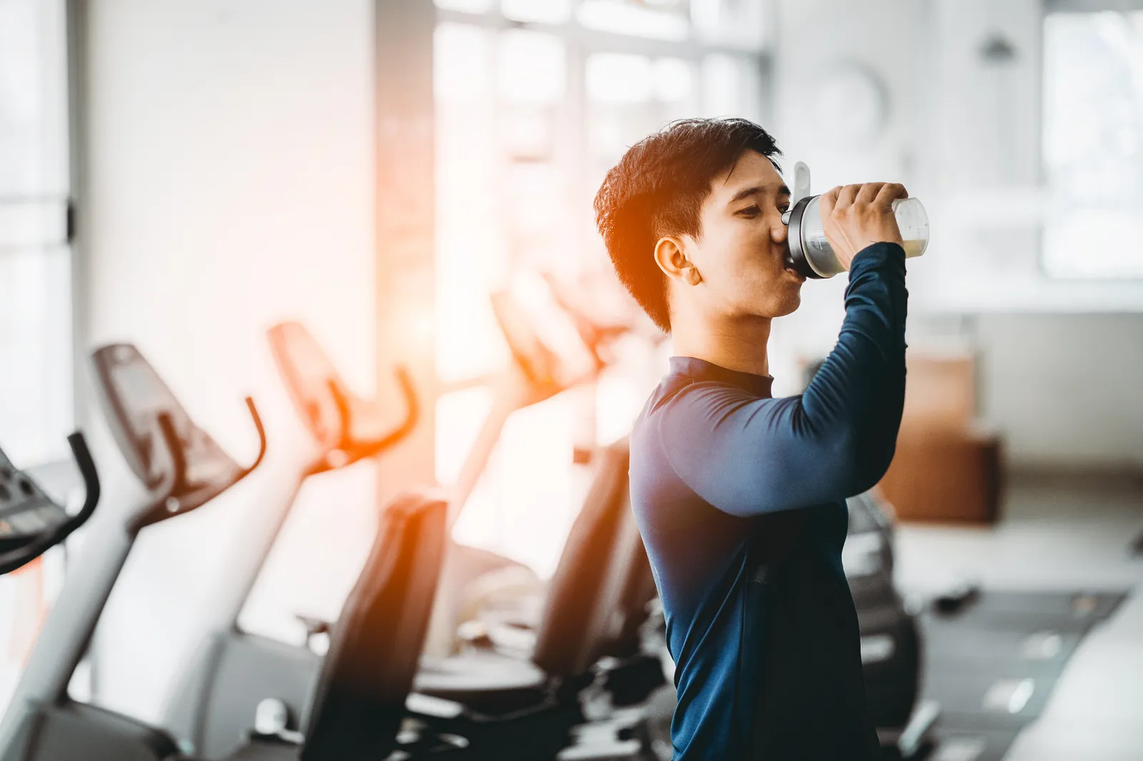 homem bebendo shake na academia depois do treino
