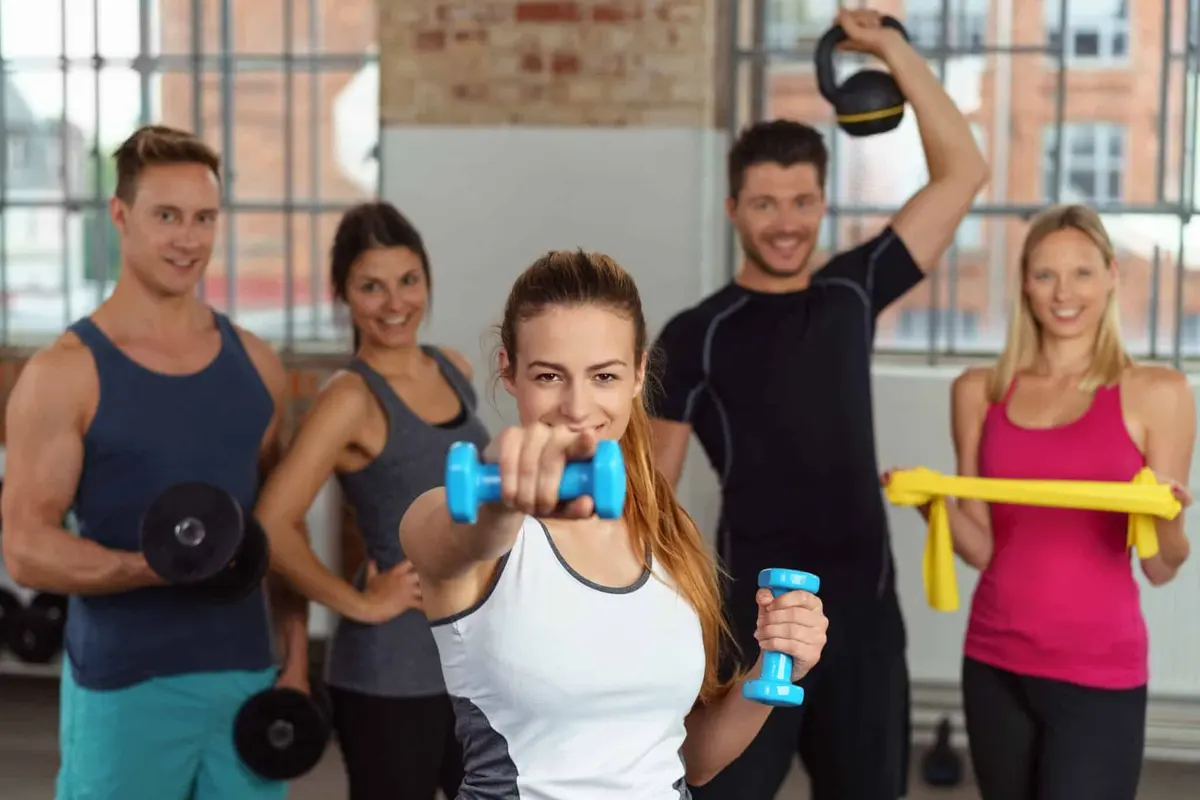 grupo treinando com halteres e elásticos na academia