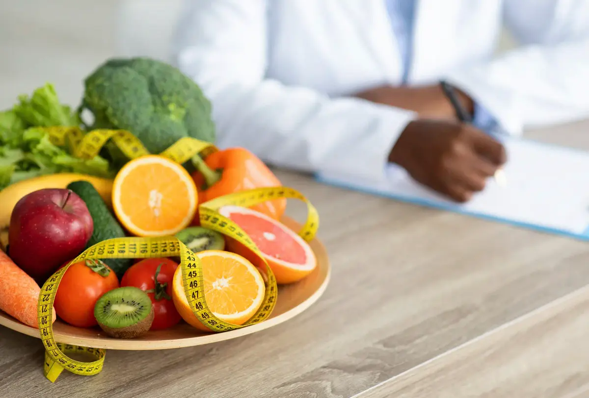 prato de frutas com fita métrica e nutricionista escrevendo