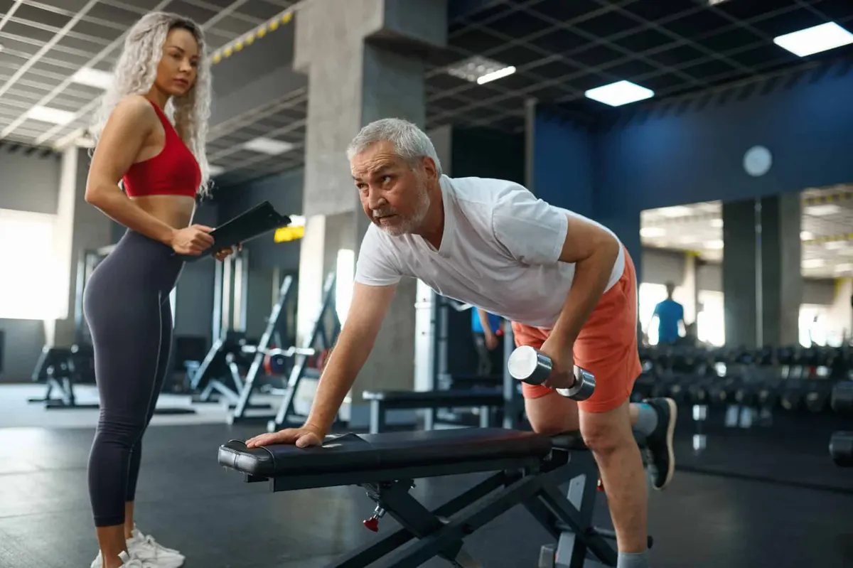 personal trainer orientando homem na remada com halter