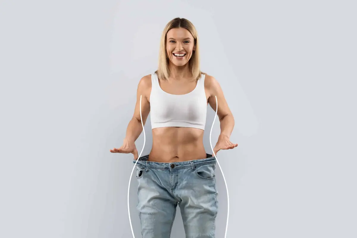 mulher feliz com calça larga depois de emagrecer