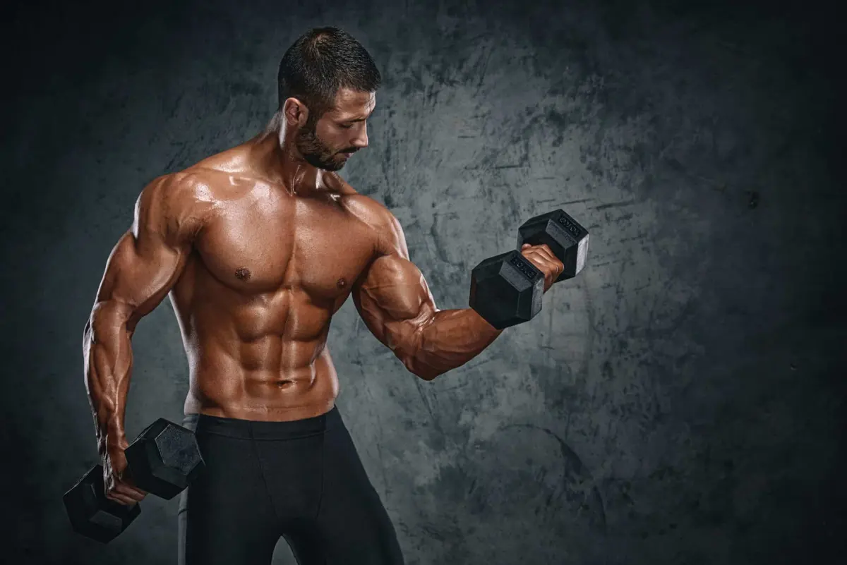 homem musculoso fazendo rosca com halteres