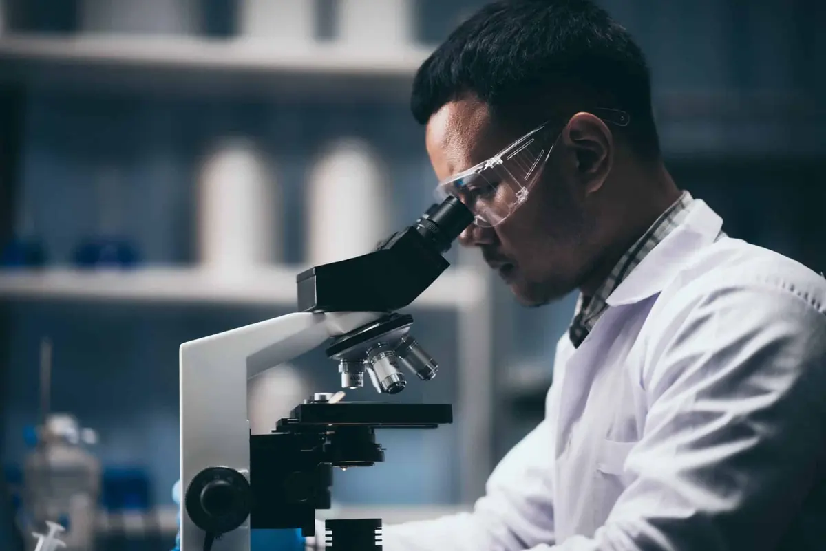 cientista olhando no microscópio