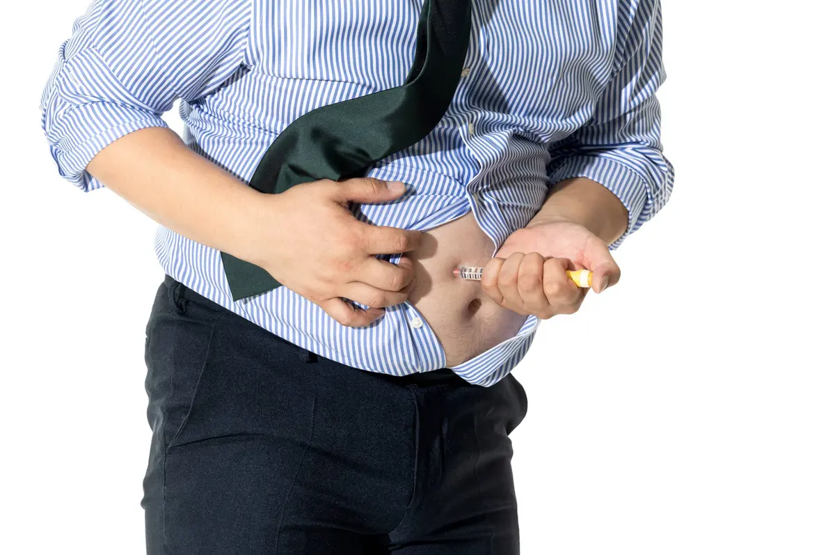 homem aplicando injeção na barriga