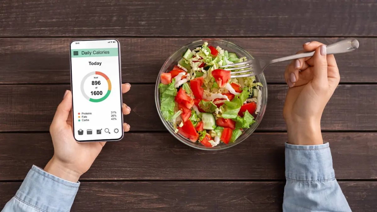celular com aplicativo de calorias ao lado de salada