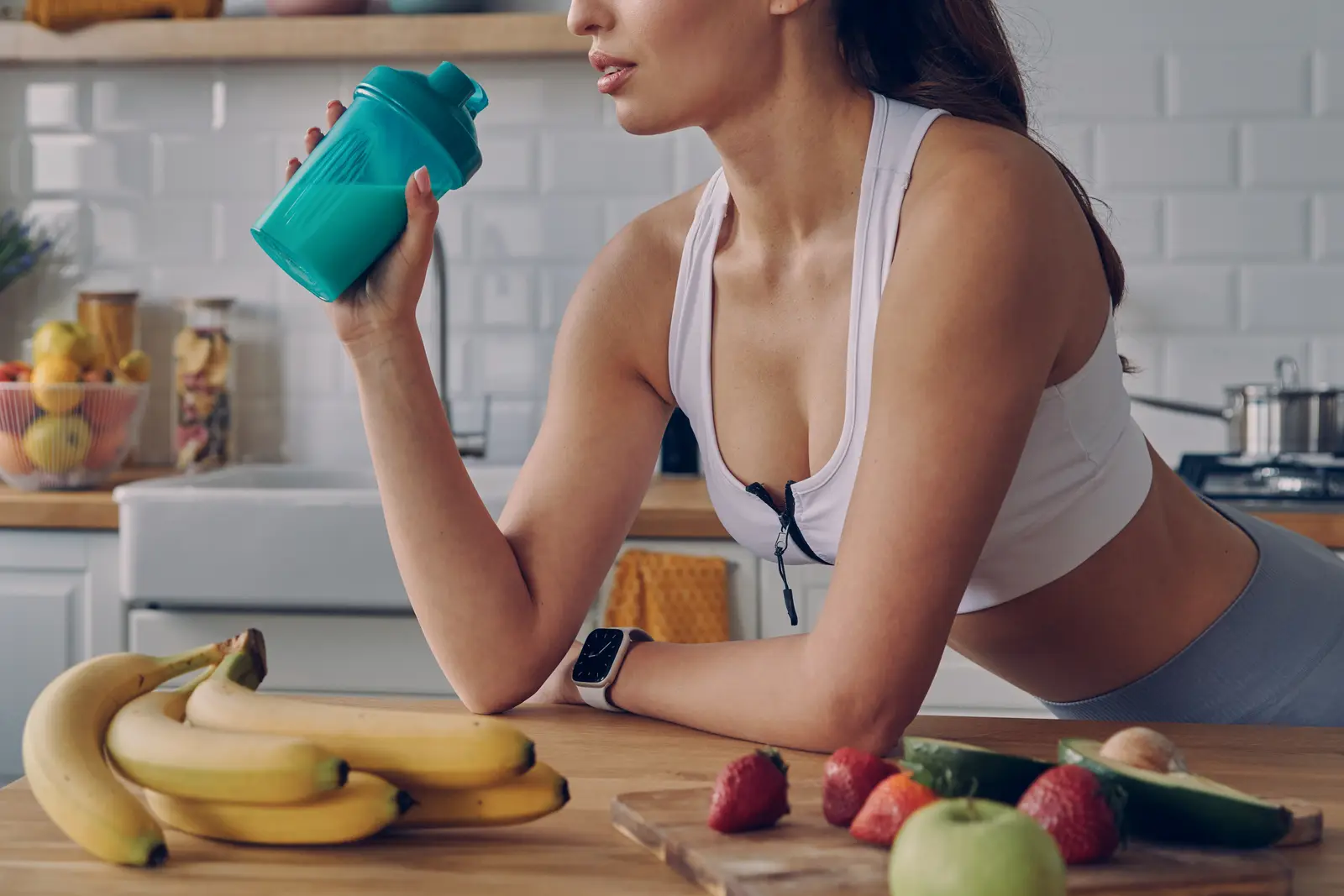 mulher tomando shake de proteína na cozinha