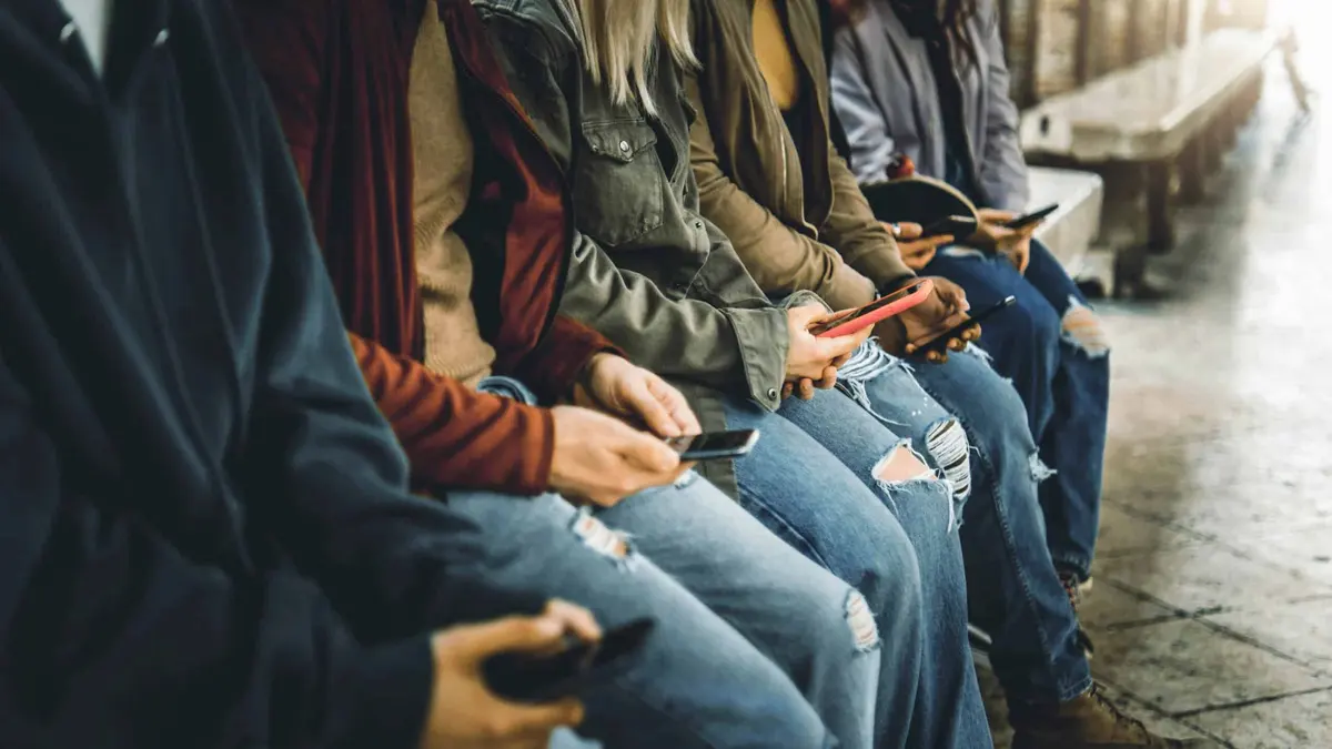 pessoas sentadas usando o celular