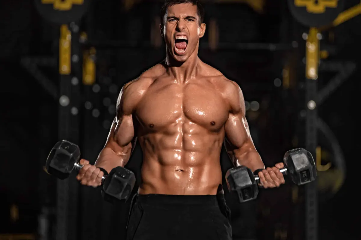 homem sem camisa segurando barra na academia