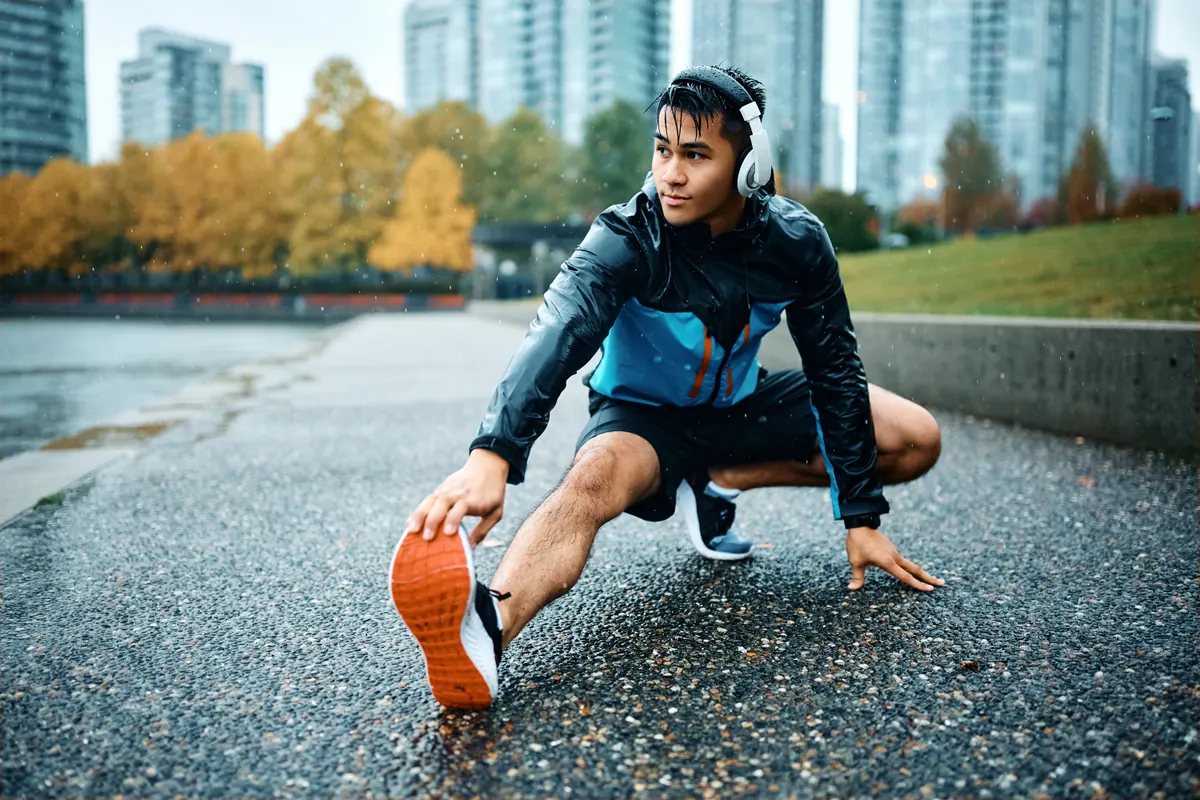 Homem alongando antes de correr na rua