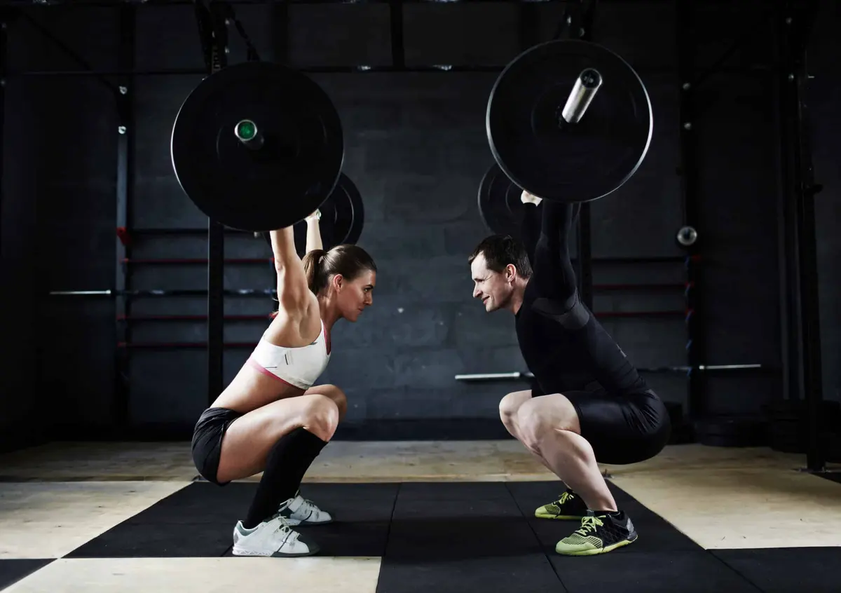 casal treinando agachamentos no crossfit