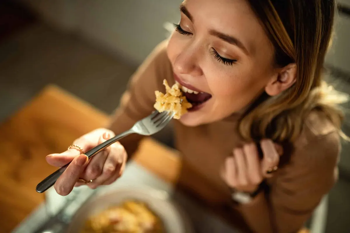 mulher comendo macarrão no jantar
