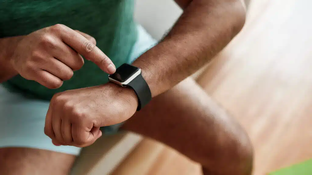 falta de tempo para exercícios Technology. Close up of hands of active man checking time, using smartwatch while doing morning workout at home. Fitness, motivation concept. Web Banner