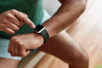 falta de tempo para exercícios Technology. Close up of hands of active man checking time, using smartwatch while doing morning workout at home. Fitness, motivation concept. Web Banner