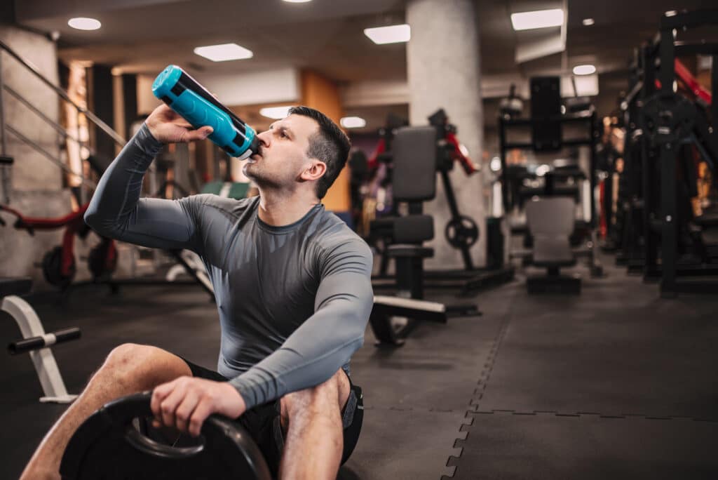 homem bebendo agua hidratação nos esportes musculação