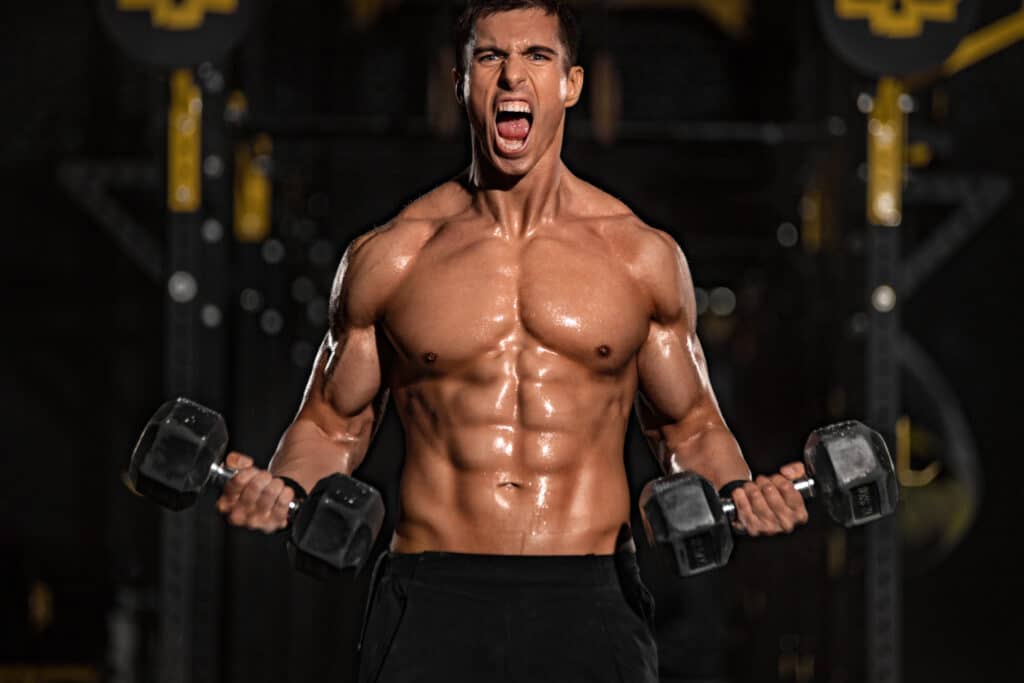 Athletic shirtless young sports man - fitness model with barbell in gym. raiva
