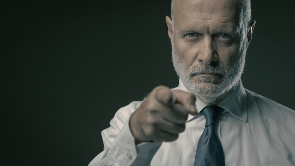 Corporate business executive pointing at camera, selection and recruitment concept